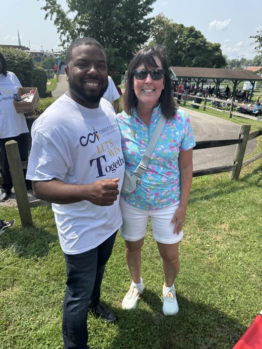 Pastor Harris smiling with a neighbor at a community gathering in the park