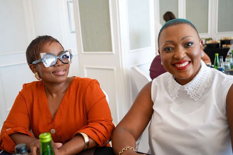 Two students smiling together at their table