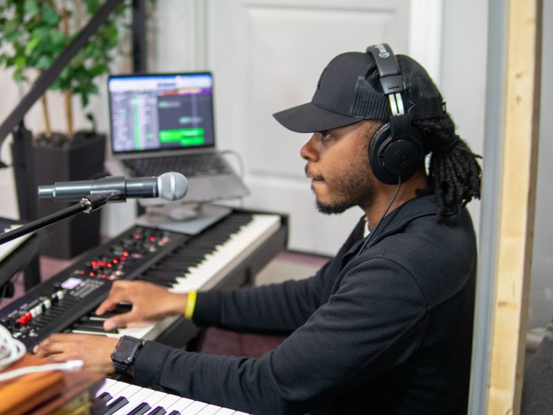 A musician in headphones playing keyboards during the service